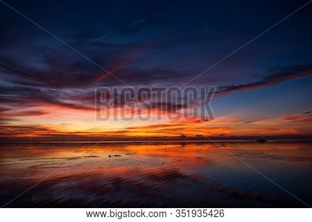 Colorful Sky Of A Sunset, Water Reflection On A Beach During Low Tide