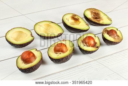 Avocado Halves On White Boards Desk, Arranged From Unripe To Overripen