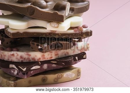 Swiss Chocolate Assortment In A Stack On Pink Background. Mix Of Different Types Of Chocolate. Choco