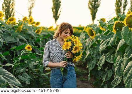 Beautiful Young Woman With Sunflowers Enjoying Nature And Laughing On Summer Sunflower Field. Woman 