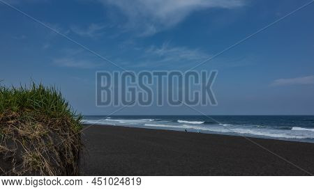 Turquoise Waves Of The Pacific Ocean Roll Onto The Shore And Foam. Tiny Silhouettes Of People On The