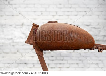 Close Up Of An Coroded Fuel Tank Of Jawa Motorcycle. White Brick Wall In The Background.