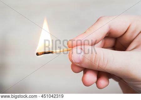 The Child Holds A Lit Match And It Burns With A Flame