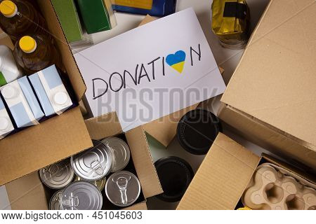 Donation For People From Ukraine. Food Donations Boxes With Grocery Products On White Desks. Top Vie