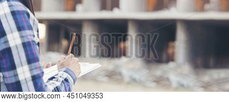 Banner Woman Construction Engineer Writing Notepad Wear Plaid Shirt Safety White Hard Hat At Constru