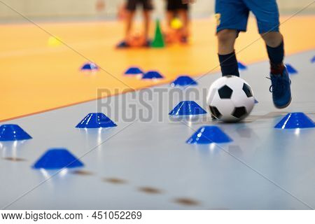 Boy In Soccer Clothes With Futsal Ball On Dribbling Drill. Kid On Indoor Soccer Training With Coach.