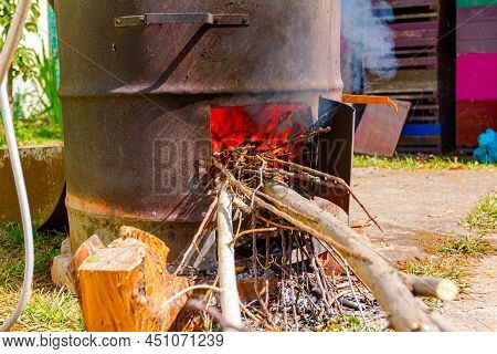 Fire Burning In Firebox Of Homemade Distillery Made Of Copper, Making Moonshine Schnapps, Alcoholic 