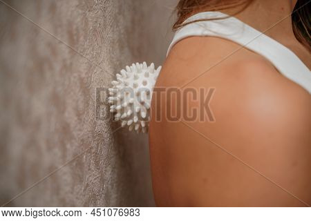 Athletic Slim Caucasian Woman Doing Thigh Self-massage With A Massage Ball Indoors. Self-isolating M