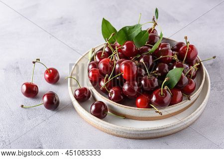 Berries Of Fresh Cherries In Two Light Ceramic Plates On A Gray Concrete Background. Horizontal. Clo
