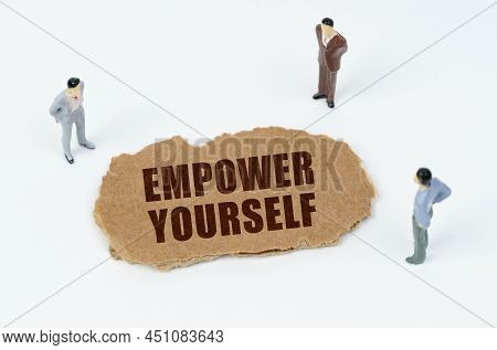 Economy And Business Concept. On A White Background, Figures Of Businessmen And Torn Cardboard With 