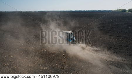 Farming: A Farmer On A Tractor Works The Field Before Sowing