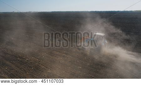 Farming: A Farmer On A Tractor Works The Field Before Sowing
