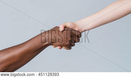 Black And White Human Hands. African And Caucasian Hands. Giving A Helping Hand To Another. Woman An