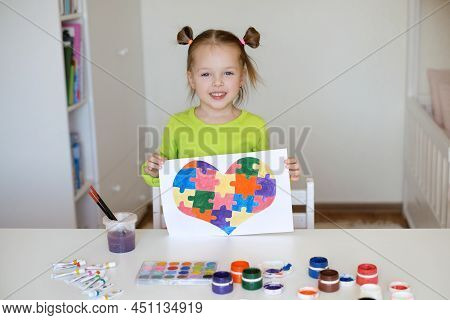 A Two-year-old Girl Shows Her Drawing In Support Of Children With Syndrome Autism. The Child Drew A 