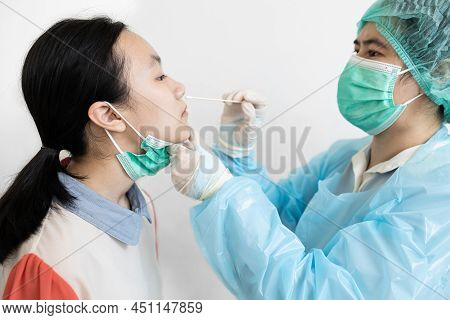 Asian Nurse In Protective Suite Taking A Swab For Nasal Mucus Test Sample From Child Girl Patient,me
