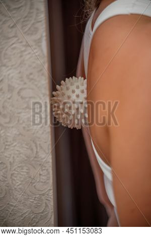 Athletic Slim Caucasian Woman Doing Thigh Self-massage With A Massage Ball Indoors. Self-isolating M