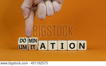 Domination Or Limitation Symbol. Businessman Turns Cubes, Changes The Word Domination To Limitation.