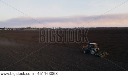 Farming: A Farmer On A Tractor Works The Field Before Sowing