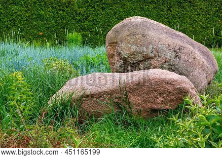 Rockery With 2 Huge Natural Stones Among Green Plants, Park Landscaping With Thuja Hedges And Planti