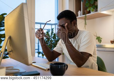 Exhausted Stressed African Software Engineer Take Off Glasses. Tired Freelancer Rub Eyes And Nose Su
