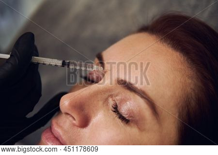 Close-up Of Beautiful Middle Aged Woman Getting Beauty Injections On Her Forehead In Wellness Spa Co