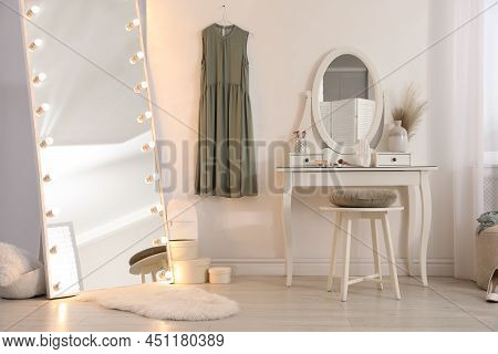 Large Mirror With Light Bulbs And Dressing Table In Stylish Room. Interior Design