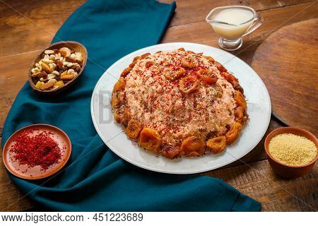 Couscous Masfouf With Dried Fruits And Nuts On A Wooden Table Next To Almond Milk And Nuts On A Blue