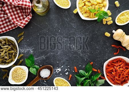 Pasta. Various Kinds Of Uncooked Pasta And Noodles Over Stone Background, Top View With Copy Space F