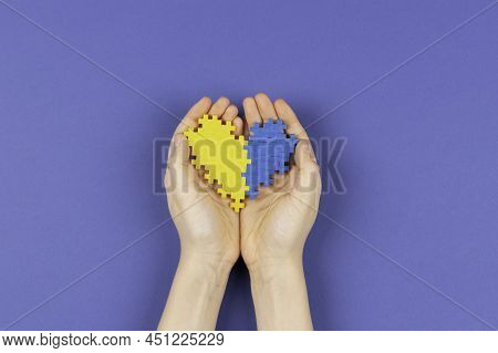 World Down Syndrome Day Background. Hands Holding Blue And Yellow Down Syndrome Awareness Day Heart 