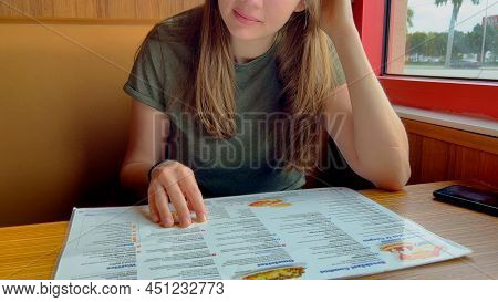 Young Woman Checking The Breakfast Menu At A Restaurant - Miami, Florida - February 20, 2022
