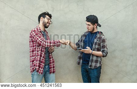 Two Young Men Clashing Their Fists, Image Of Two Young Men Bumping Their Fists In A Friendly Way, Cl