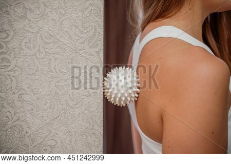 Athletic Slim Caucasian Woman Doing Thigh Self-massage With A Massage Ball Indoors. Self-isolating M