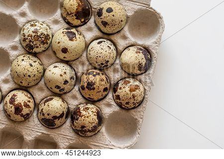 Spotted Quail Eggs In An Egg Box On A Light Background, Natural Eco-friendly Products.