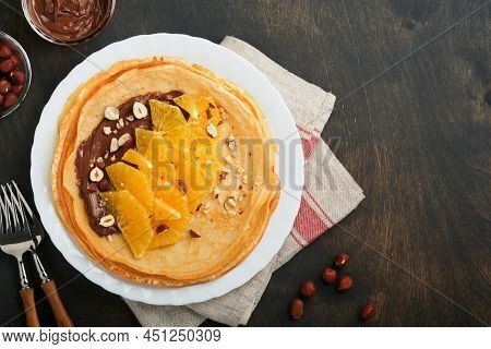 Crepes Suzette With Oranges. Thin Crepes With Chocolate Spread, Hazelnuts And Orange Slices Fruit In