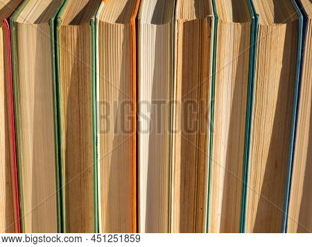 Old, Battered And Faded Hardcover Books Or Textbooks In A Bookstore Or Library. A Stack Of Hardcover