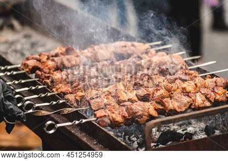 Pork Meat Skewer, Grilled Or Roasted In A Barbecue On An Open Fire And Flames, Shashlik Or Shashlyk 