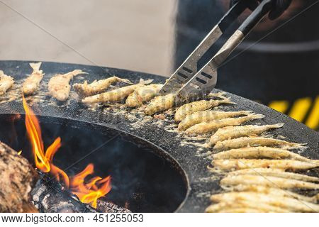 Preparing Traditional Tasty European Smelt Fried Fish Being Cooked On An Open Fire In A Regional Str