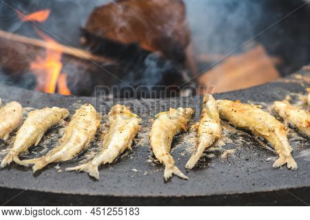 Preparing Traditional Tasty European Smelt Fried Fish Being Cooked On An Open Fire In A Regional Str