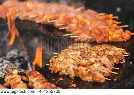 Preparing Chicken Meat Skewers, Grilled Or Roasted In A Barbecue On An Open Fire And Flames, Shashli