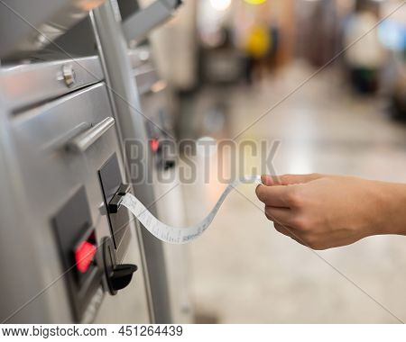 A Woman Takes A Train Ticket From A Self-service Ticket Office.