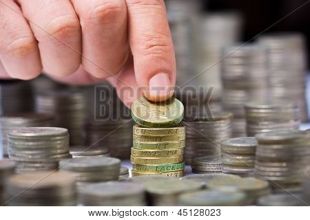 Bir erkek eli ile İngiliz Sterlini sikke yığını closeup