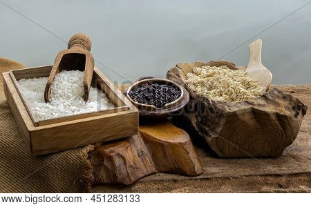 Various Types Of Rice : Brown Rice, Jasmine Rice And Riceberry On Old Wooden Table. Organic Raw Rice