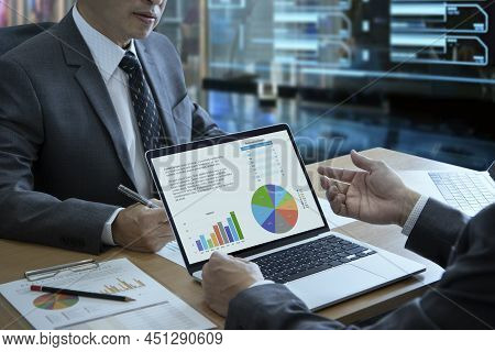 Two Businessmen With Laptop Computer Notebook In A Modern Office Analyzing Business Information On B
