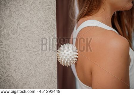Athletic Slim Caucasian Woman Doing Thigh Self-massage With A Massage Ball Indoors. Self-isolating M