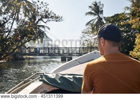 Man Traveling On Boat Against Bridge In Beautiful Tropical Landscape. Madu River In Sri Lanka.