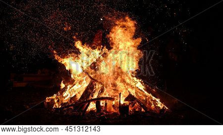 Colorful Lames Dance On Charred Logs In A Wood Fire. Closeup Of Fire Burning In An Old Fireplace, Ca