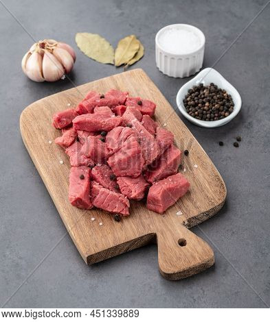Chopped Topside Meat On Wooden Board  Over Stone Background With Seasonings.