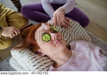 Little Chidlren Putting Cucumber On Their Mothers Face And Doing Face Massage To Her At Home.