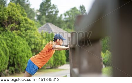 Man Athlete Doing Workout, Stetching His Arms At A Park.