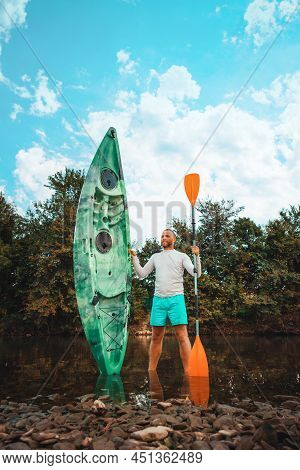 Kayaking. A Man Standing At The River And Posing With Kayak. Vertical. Recretion At The National Par
